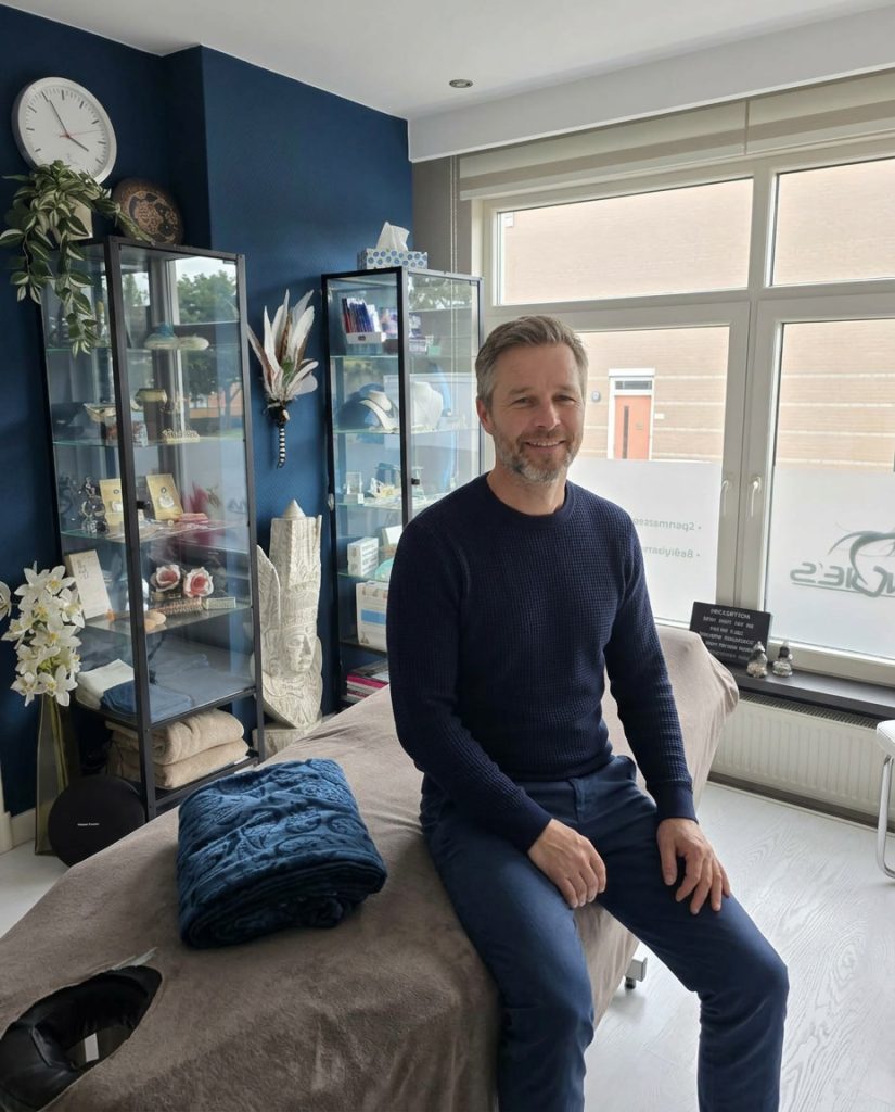 Man zit ontspannen glimlachend op de behandeltafel tijdens het RESET-traject bij Angie's Body Care in Schiedam